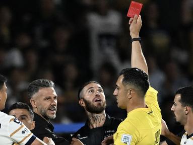 Pemain Monterrey, Sergio Ramos mendapatkan kartu merah dari wasit Ismael Rosario López setelah melakukan pelanggaran dalam laga lanjutan Liga Meksiko atau Liga MX Clausura antara Puma melawan Monterrey di Olimpico Universitario Stadium, Meksiko pada Minggu (16/03/2025). (AFP/Yuri Cortez)