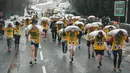 Peserta membawa karung berisi batu bara saat mengikuti World Coal Carrying Championships di Desa Gawthorpe, Wakefield, Inggris Utara, Senin (2/4). Kompetisi  tahunan mengakut karung batu bara ini dalam memperingati Senin Paskah. (OLI SCARFF/AFP)