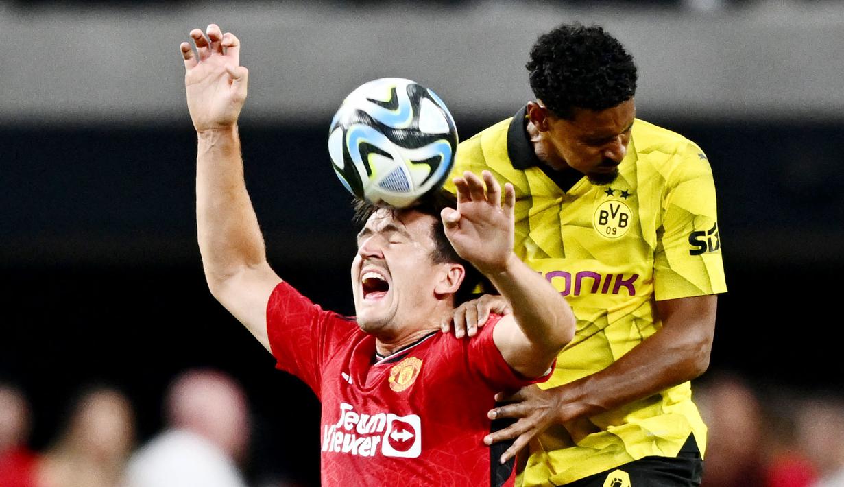 Bek Manchester United, Harry Maguire, duel udara dengan pemain Borussia Dortmund, Sebastien Haller, dalam laga uji coba pramusim yang digelar di Allegiant Stadium, Las Vegas, Senin (31/7/2023). MU takluk 2-3 dari Dortmund. (Photo by Patrick T. Fallon / AFP)