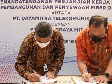 Dirut PT Alita Praya Mitra (Alita) Teguh Prasetya (kanan) dan Dirut PT Dayamitra Telekomunikasi, Tbk (Mitratel) Theodorus Ardi Hartoko (kiri) menandatangani naskah kerja sama pembangunan dan penyewaan jaringan fiber optik sepanjang 6.000 KM, di Jakarta, Jumat (24/12/2021). (Liputan6.com/HO/Alwi)