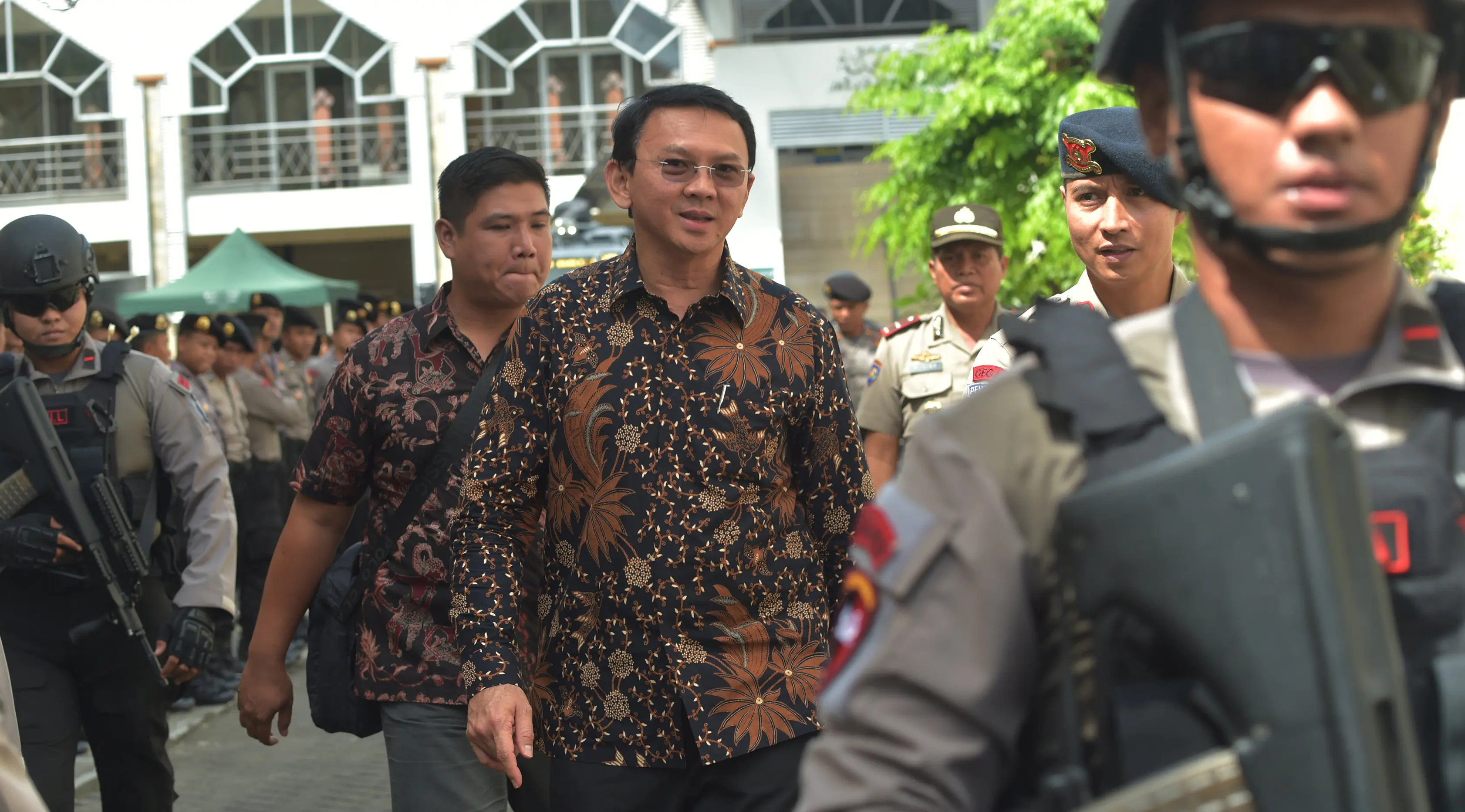 Gubernur DKI Jakarta nonaktif, Basuki Tjahaja Purnama (Ahok) berjalan meninggalkan gedung PN Jakarta Utara, Selasa (20/12). Ahok mendapat pengawalan polisi anti-teror usai menjalani sidang kedua kasus dugaan penistaan. (REUTERS/Adek BERRY/Pool)