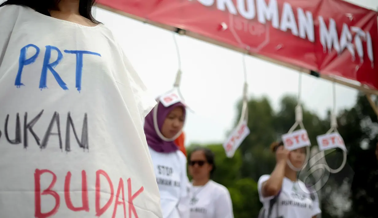 Massa Buruh Migrant memakai baju bertuliskan 'PRT Bukan Budak' saat menggelar aksi tolak hukuman mati yang bersamaan dengan peringatan Hari Buruh (May Day) di depan Istana Merdeka, Jumat (1/5/2015). (Liputan6.com/Faizal Fanani)