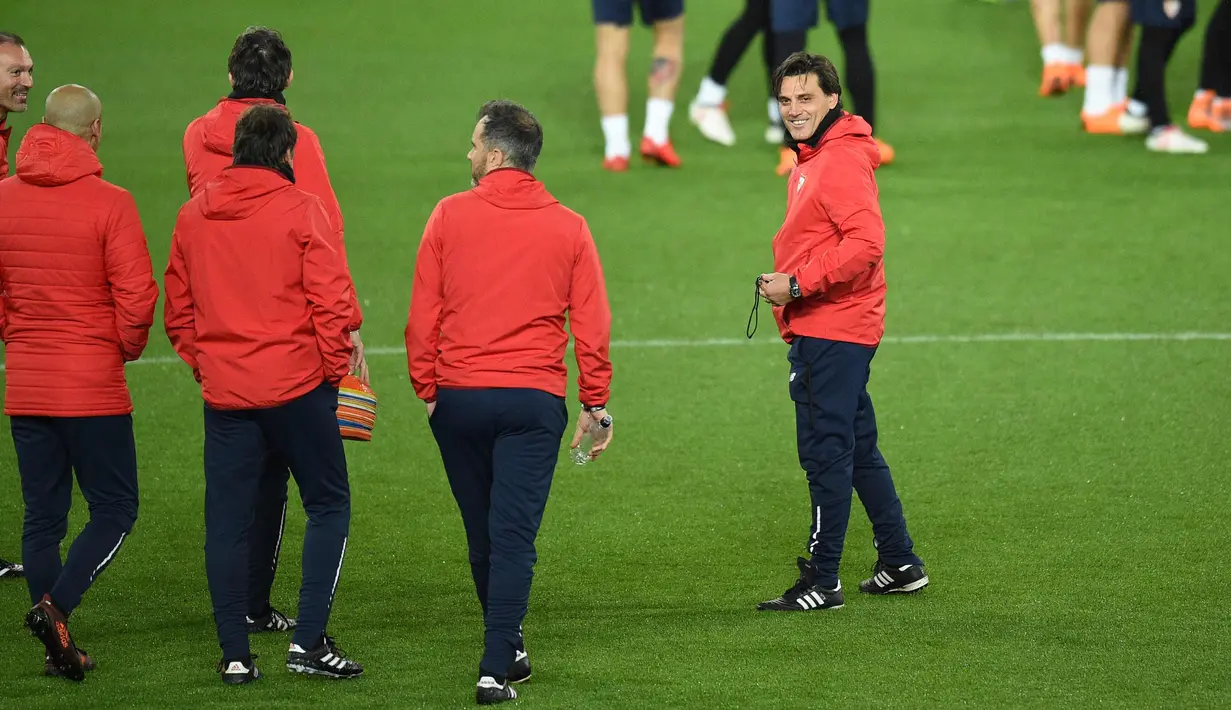 Pelatih Sevilla Vincenzo Montella (kanan) dan asistennya melihat para pemainnya latihan di stadion Old Trafford di Manchester, Inggris (12/3). Sevilla akan melawan Manchester United pada leg kedua babak 16 besar Liga Champions. (AFP Photo/Oli Scarff)