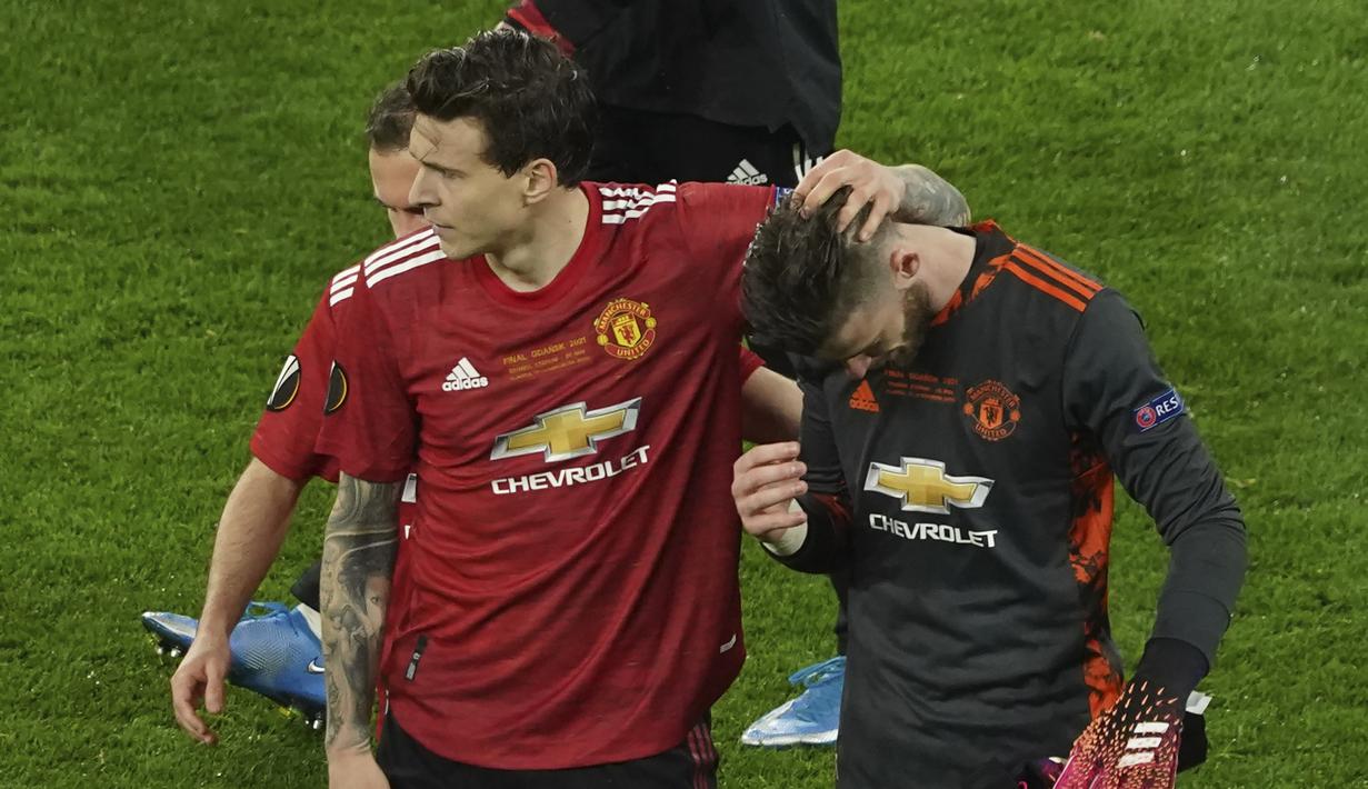 Kiper Manchester United, David De Gea (kanan) dihibur Victor Lindelof usai gagal mencetak gol ke gawang Villarreal dalam babak adu penalti laga final Liga Europa 2020/2021 di Gdansk Stadium, Polandia, Rabu (26/5/2021). Manchester United kalah 11-12 (1-1) dari Villarreal. (AP/Adam Warzawa/Pool)