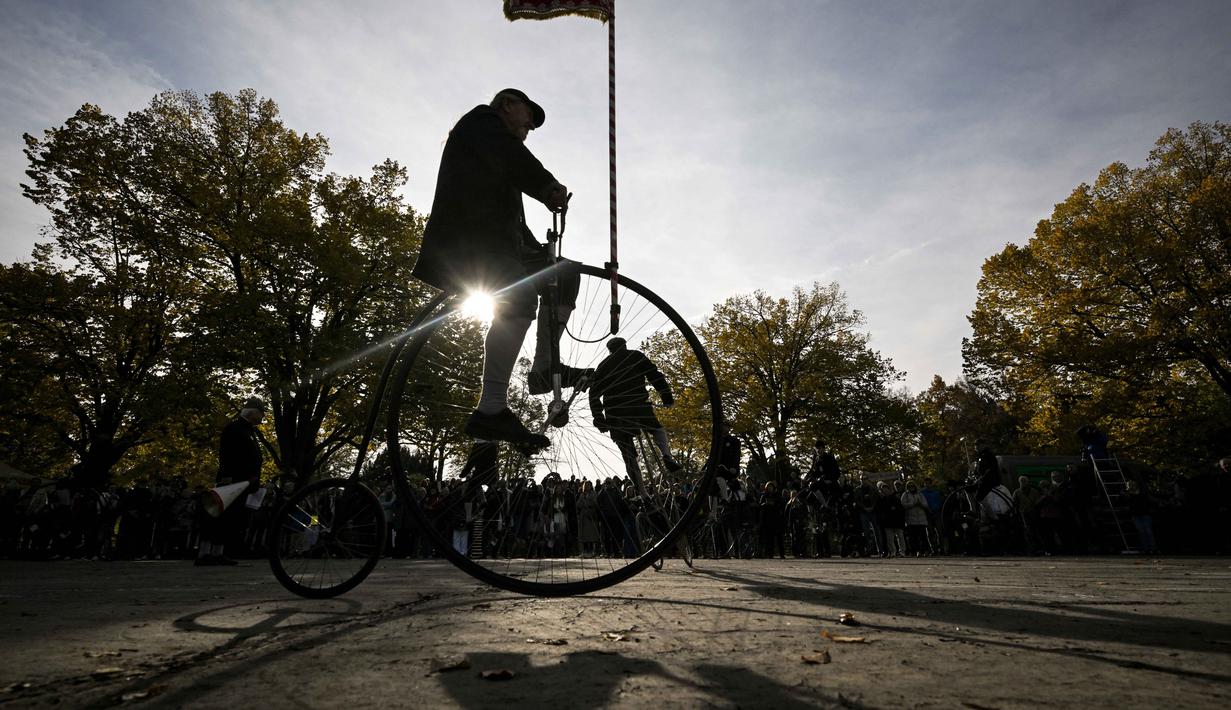Seorang penggemar sepeda yang mereka sebut penny-farthing, atau yang juga dikenal sebagai high wheel, dalam kompetisi tradisional 'One Mile Race' di Taman Letna, Praha, Republik Ceko, pada 1 November 2025. Untuk diketahui, penny-farthings merupakan model sepeda dengan satu roda besar dan satu roda kecil. (Michal Cizek/AFP)
