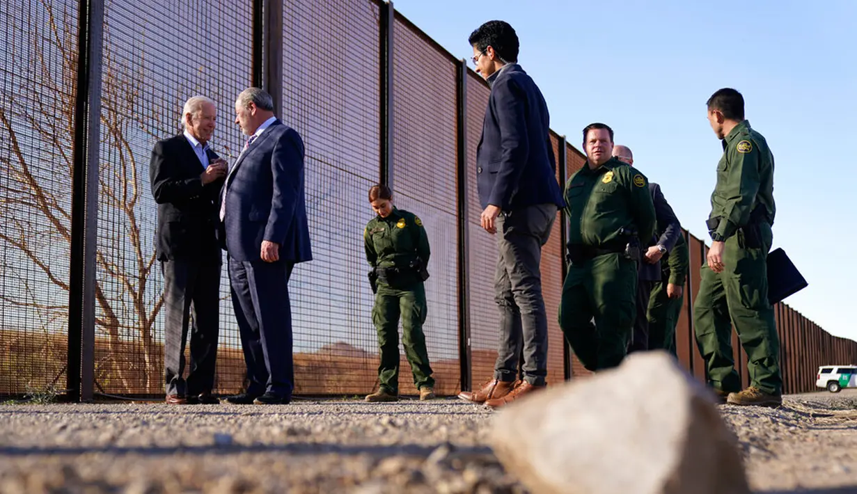 Presiden Amerika Serikat Joe Biden berbicara dengan Wali Kota Kota El Paso Oscar Leeser saat mereka berdiri di samping bentangan perbatasan AS-Meksiko di El Paso, Texas, AS, 8 Januari 2023. Kunjungannya ini dilakukan beberapa hari setelah mengumumkan bahwa sebanyak 30.000 warga Kuba, Nikaragua, Haiti, dan Venezuela akan diizinkan masuk ke AS setiap bulan. (AP Photo/Andrew Harnik)