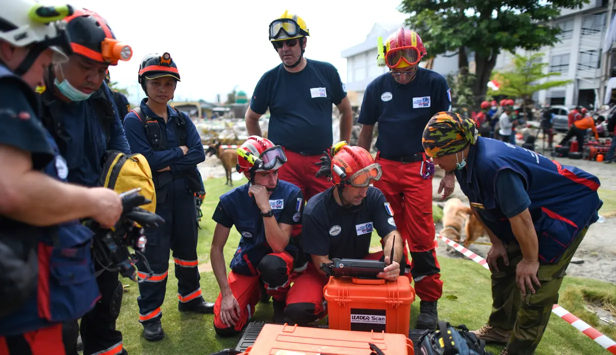 Anggota dari Pemadam Kebakaran Darurat Internasional Prancis menyiapkan peralatan mereka untuk mencari korban gempa dan tsunami di Palu, Sulawesi Tengah (4/10). (AFP Photo/Jewel Samad)