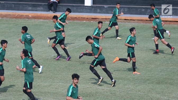 Pemain Timnas Indonesia U-19 melakukan lari pemanasan saat latihan di Lapangan B Kompleks GBK, Jakarta, Selasa (18/9). Latihan ini persiapan  PSSI Anniversary Cup U-19 dan Piala AFC U19. (Liputan6.com/Helmi Fithriansyah)