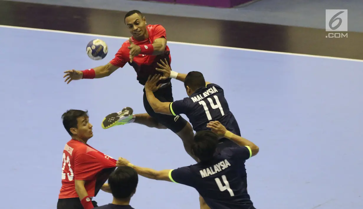 Pemain bola tangan Indonesia, Victorius Rafael T (kiri) mencoba membongkar pertahanan Malaysia pada penyisihan grup 3 bola tangan Asian Games 2018 di GOR PP POPKI, Jakarta, Minggu (26/8). Indonesia unggul 31-22. (Liputan6.com/Helmi Fithriansyah)
