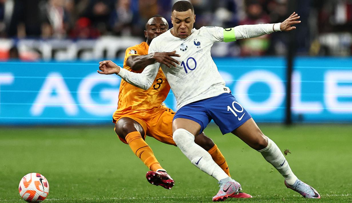 Pemain Timnas Prancis, Kylian Mbappe (kanan) berebut bola dengan pemain Timnas Belanda, Lutsharel Geertruida pada laga Grup B Kualifikasi Euro 2024 yang berlangsung di Stade de France, Sabtu (25/03/2023) WIB. Les Bleus menang dengan skor 4-0. (AFP/Anne-Christine Poujoulat)