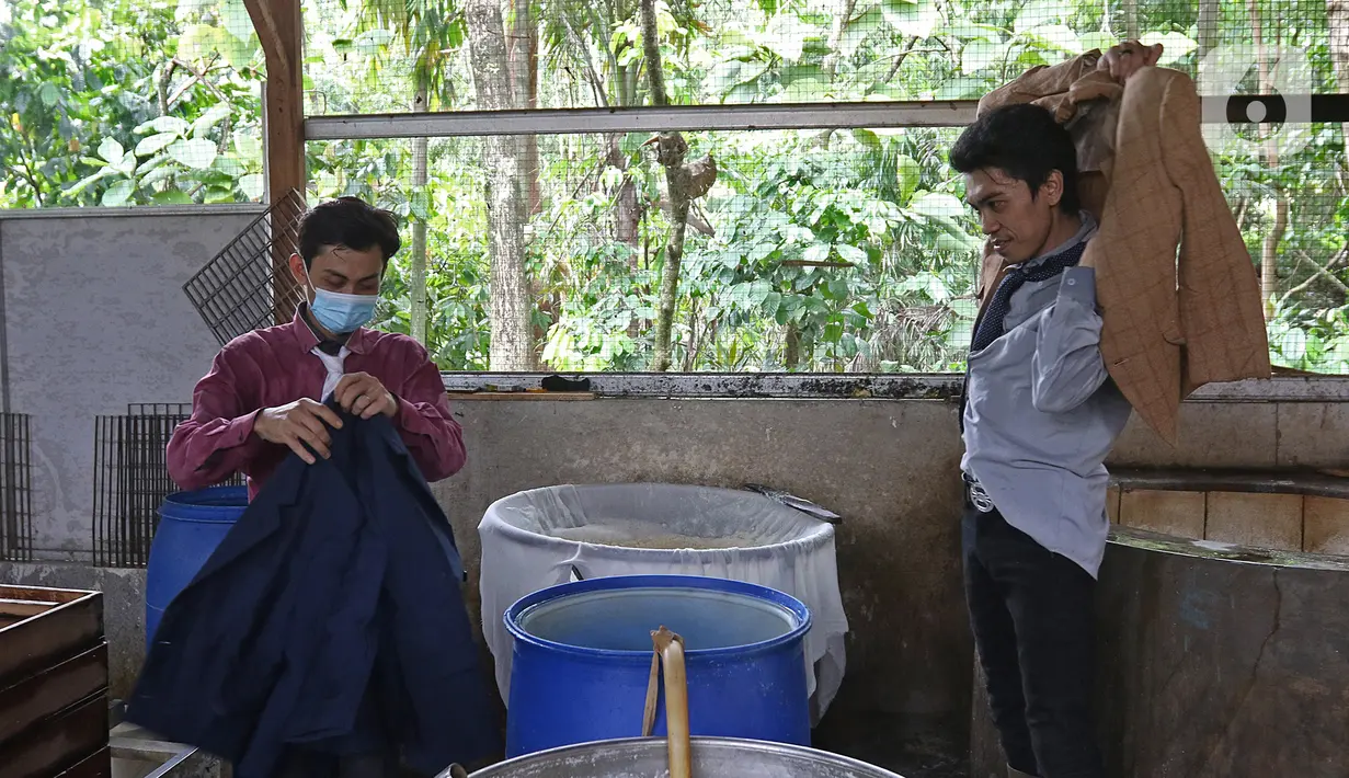 Pekerja bersiap memakai pakaian seperti pekerja kantor untuk memproduksi tahu di daerah Sukaraja, Kabupaten Bogor, Senin (14/12/2020). Ide ini dilakukan untuk menciptakan image baru bahwa bekerja di pabrik juga bisa rapi, bersih dan merasakan seperti pekerja kantor. (Liputan6.com/Herman Zakharia)