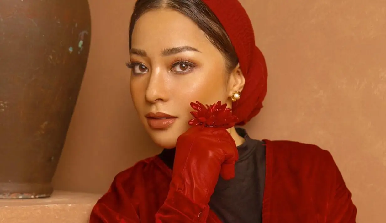 Salah satu penampilan menawannya kala melakukan pemotretan dengan busana serba merah. Ia tampak memakai kerudung serta sarung tangan dengan warna sneada.(Liputan6.com/IG/@nikitawillyofficial94)