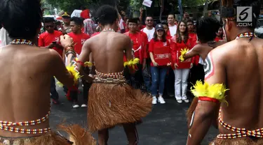 Tarian tradisional Papua mengiringi kedatangan kader Partai Solidaritas Indonesia (PSI) di kantor KPU, Selasa (10/10). Dipimpin sang ketua umum, Grace Natalie, PSI datang untuk mendaftarkan partainya sebagai peserta Pemilu 2019. (Liputan6.com/Johan Tallo)