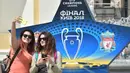 Dua orang warga foto di depan hiasan Liga Champions di kota Kiev, Ukraina, Selasa (22/5/2018). Kiev menjadi tuan rumah final Liga Champions 2018 antara Real Madrid kontra Liverpool. (AFP/Sergei Supinsky)
