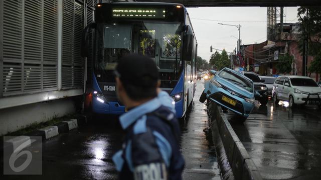 Sebuah Taksi Tabrak Pembatas Busway Halte Jati Padang
