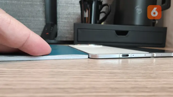 <p>Oppo Find N5 memiliki tebal bodi kurang lebih sama dengan buku pasport 48 halaman. (Liputan6.com/ Yuslianson)</p>