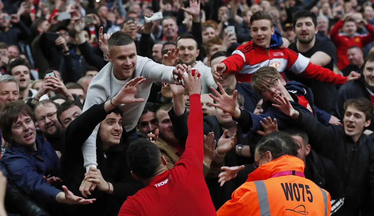 Pemain Manchester United, Jesse Lingard, melempar jerseynya kearah suporter Manchester United usai menang atas Everton pada semifinal Piala FA di Stadion Wembley, London, Sabtu (23/4/2016). (Reuters/Eddie Keogh)