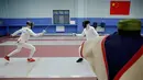 Dua murid berlatih anggar di Sekolah Atlet Shichahai, China (18/5). Latihan keras ini bisa membuat anak-anak menangis dan cedera ini diharapkan mampu menjadikan atlet berkualitas. (REUTERS/Aly Song)