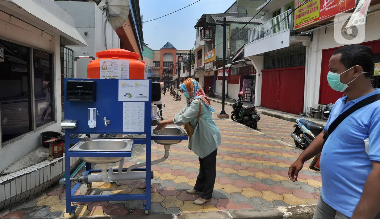 Warga menggunakan fasilitas tempat cuci tangan atau wastafel portabel di Pasar Bogor, Jalan Suryakencana, Kota Bogor, Sabtu (29/3/2020). Wastafel portabel itu sebagai upaya meningkatkan perilaku hidup bersih dan sehat (PHBS) juga mencegah penyebaran pandemi virus Corona. (merdeka.com/Arie Basuki)