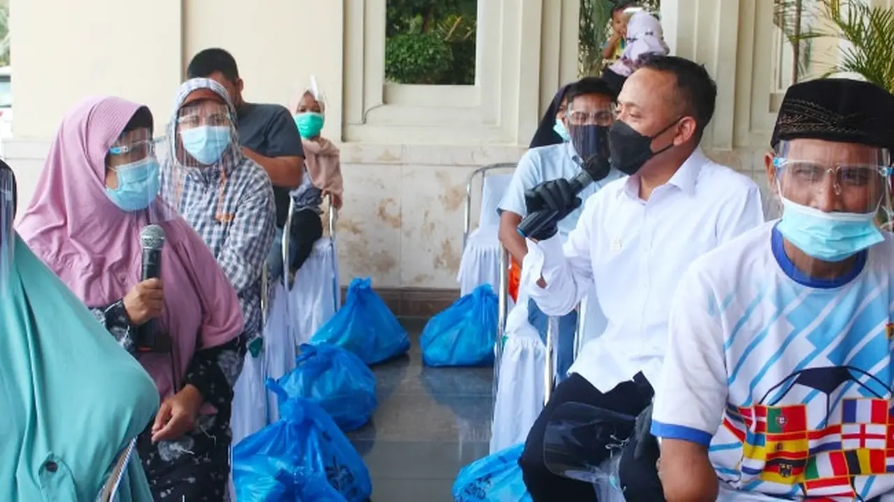 CEO PTPN V Jatmiko K Santosa berbincang dengan penyandang disabilitas di Pekanbaru ketika menyalurkan 2.000 paket sembako.