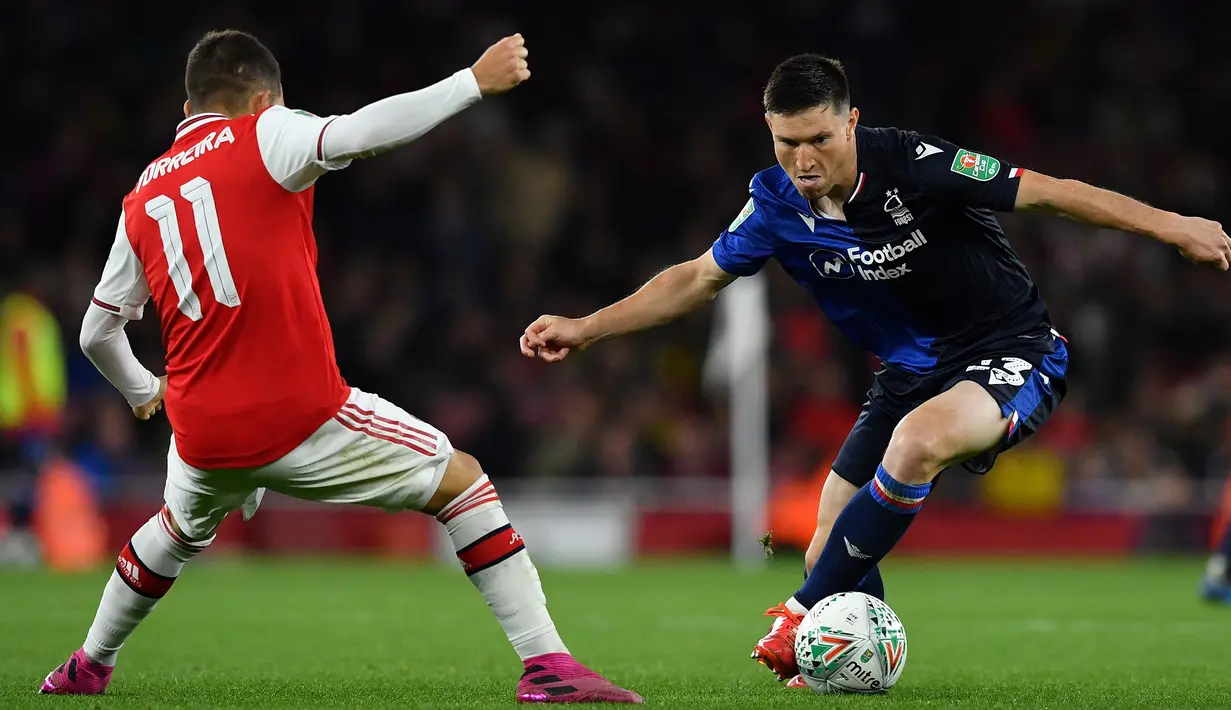 Gelandang Nottingham Forest, Joe Lolley berusaha melewati gelandang Arsenal, Lucas Torreira pada babak ketiga Piala Liga Inggris musim 2019-2020 di Stadion Emirates di London (24/9/2019). Arsenal menang telak 5-0 atas Nottingham Forest. (AFP Photo/Ben Stansall)