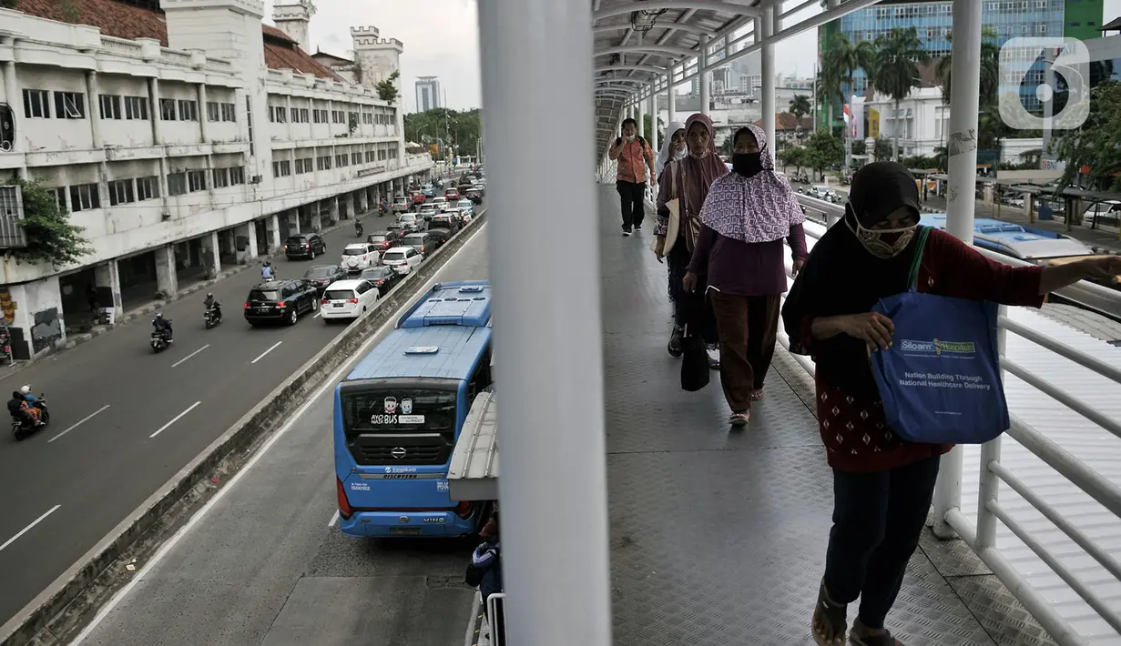Pejalan kaki berjalan di JPO Halte Harmoni, Jakarta, Selasa (16/6/2020). PT Transjakarta mencatat sejak penerapan Pembatasan Sosial Berskala Besar (PSBB) Transisi, pengguna bus Transjakarta naik 22 persen dibandingkan saat PSBB. (merdeka.com/Iqbal Nugroho)