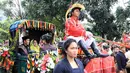 Sebelum duduk di pelaminan, pengantin yang tengah berbahagia itu menjalani kirab budaya. Diarak menggunakan kereta kuda dan melibatkan puluhan betor (becak motor). (Deki Prayoga/Bintang.com)