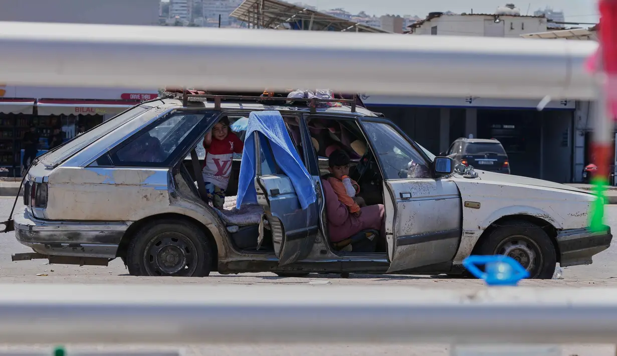 Keluarga pengungsi yang meninggalkan desa mereka di Lebanon Selatan berlindung di dalam mobil mereka di jalan di kota pelabuhan selatan Sidon, Rabu 10 Juni 2026. (AP Photo/Mohammed Zaatari)
