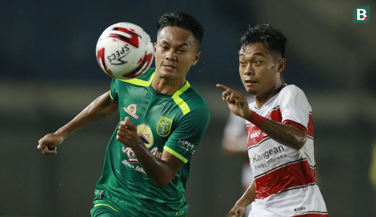 Gelandang Persebaya Surabaya, Koko Ari (kiri) berebut bola dengan striker Madura United, Mochammad Kevy dalam laga matchday ke-2 Grup C Piala Menpora 2021 di Stadion Si Jalak Harupat, Bandung, Minggu (28/3/2021). (Bola.com/M Iqbal Ichsan)