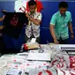 Petugas menunjukkan barang bukti saat rilis penangkapan tersangka penjual kaus berlogo palu arit secara online di Bareskrim Polri, Jakarta, Jumat (30/12). HS ditangkap karena dianggap menyebarkan paham komunisme dan marxisme (Liputan6.com/Johan Tallo)