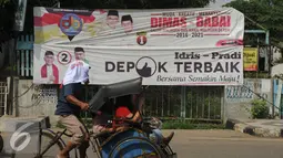 Warga melintas di depan spanduk dua pasang calon yang bertarung di Pilkada Kota Depok, Jawa Barat, Rabu (2/12). Kota Depok menjadi salah satu daerah yang akan melaksanakan Pilkada serentak pada 9 Desember mendatang. (Liputan6.com/Helmi Fithriansyah)