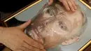 Pengunjung menyentuh foto 3D Vladimir Putin di perpustakaan khusus tunanetra di Siberia, Rusia (15/3). Foto 3D tersebut dibuat untuk para tuna netra yang tidak mengetahui bagaimana wajah dan sosok Vladimir Putin. (REUTERS/Ilya Naymushin)