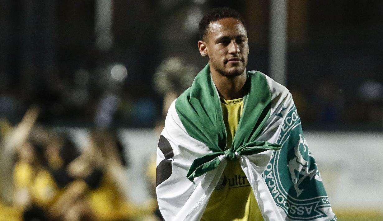 Bintang Brasil, Neymar, memakai bendera dari klub Chapecoense usai menjalani laga amal. Neymar bersama Robinho menjadi inisiator pertandingan amal yang dilakukan untuk mengenang para pemain Chapecoense. (AFP/Miguel Schincariol)