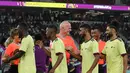 Presiden FIFA Gianni Infantino mengenakan seragam wasit menyapa para pemain saat memimpin pertandingan persahabatan antara para Legenda FIFA dan para pekerja yang berbasis di Qatar di Stadion Al Thumama di Doha (12/12/2022). (AFP/Karim Jaafar)