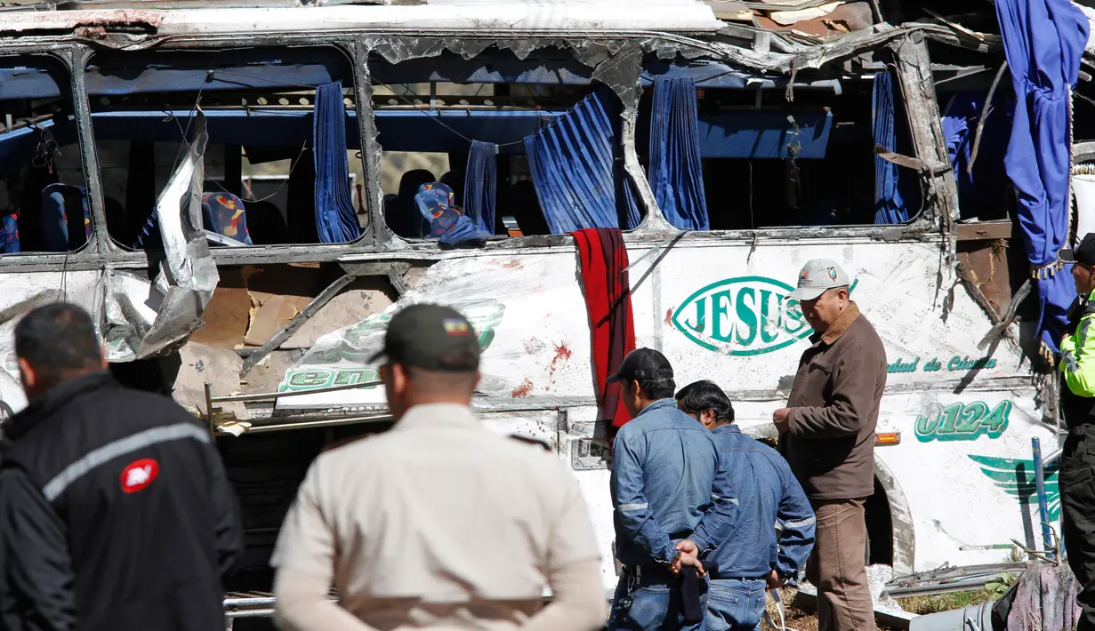 Petugas penyelamat berkumpul di sebuah bus pembawa turis asal Kolombia dan Venezuela yang terlibat kecelakaan di Pifo, Ekuador, Selasa (14/8). Bus menabrak sebuah kendaraan dan terbalik, lalu menghantam tiga rumah di sisi jalan. (AP Photo/Carlos Noriega)