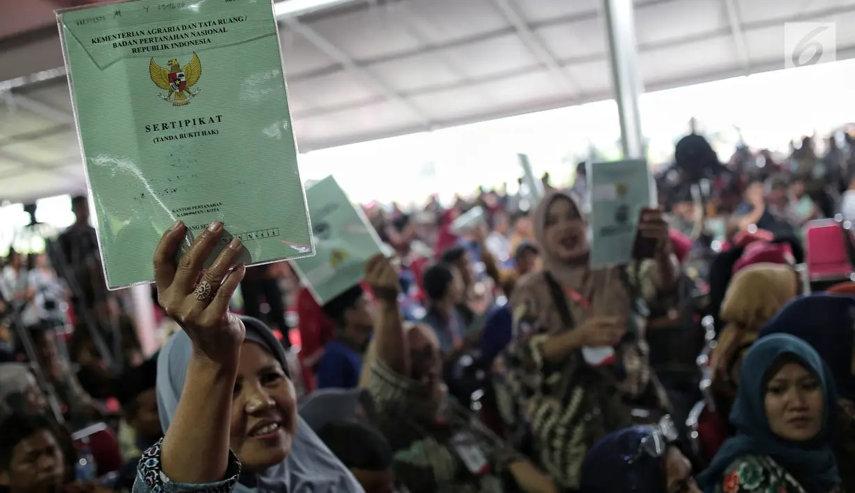 Warga menunjukkan sertifikat tanah yang baru diserahkan oleh Presiden Joko Widodo di Pusat Penerbangan Angkatan Darat, Pondok Cabe,  Tangsel, Jumat (25/1). Pada kesempatan ini, 40.172 sertifikat tanah dibagikan oleh Jokowi (Liputan6.com/Faizal Fanani)