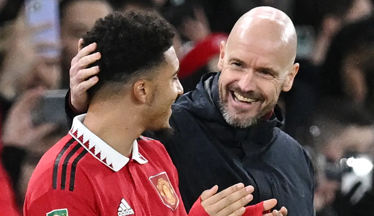 Pemain Manchester United, Jadon Sancho, tersenyum saat akan dimasukkan Erik ten Hag melawan Nottingham Forest pada leg kedua babak semifinal Carabao Cup, Jumat (2/2/2023). Sancho bermain ketika Manchester United menaklukkan Nottingham 2-0 pada leg kedua babak semifinal Carabao Cup, Jumat (2/2/2023). (AFP/Paul Ellis)