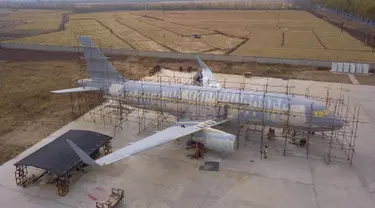 Foto udara memperlihatkan orang-orang menyelesaikan pembuatan replika pesawat Airbus A320 skala penuh di Kaiyuan, timur laut China, 25 Oktober 2018. Replika pesawat itu dibuat seorang petani, Zhu Yue yang merupakan penggemar dunia penerbangan. (STR/AFP)