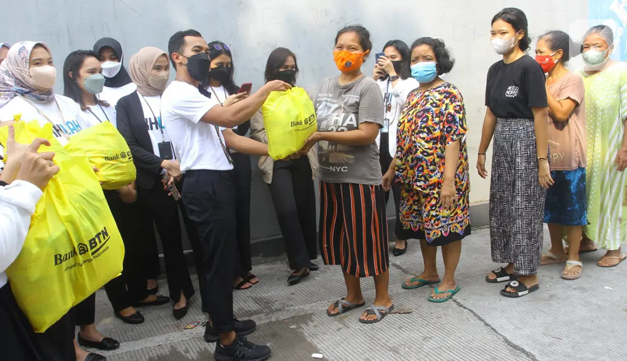 Karyawan milenial Bank BTN membagikan bantuan paket sembako kepada masyarakat kurang mampu di kawasan Menara Bank BTN di Jakarta, Senin (11/4/2022). Paket sembako tersebut merupakan bentuk Tanggung Jawab Sosial dan Lingkungan (TJSL) Bank BTN sebagai bagian dari BUMN. (Liputan6.com/HO/BTN)