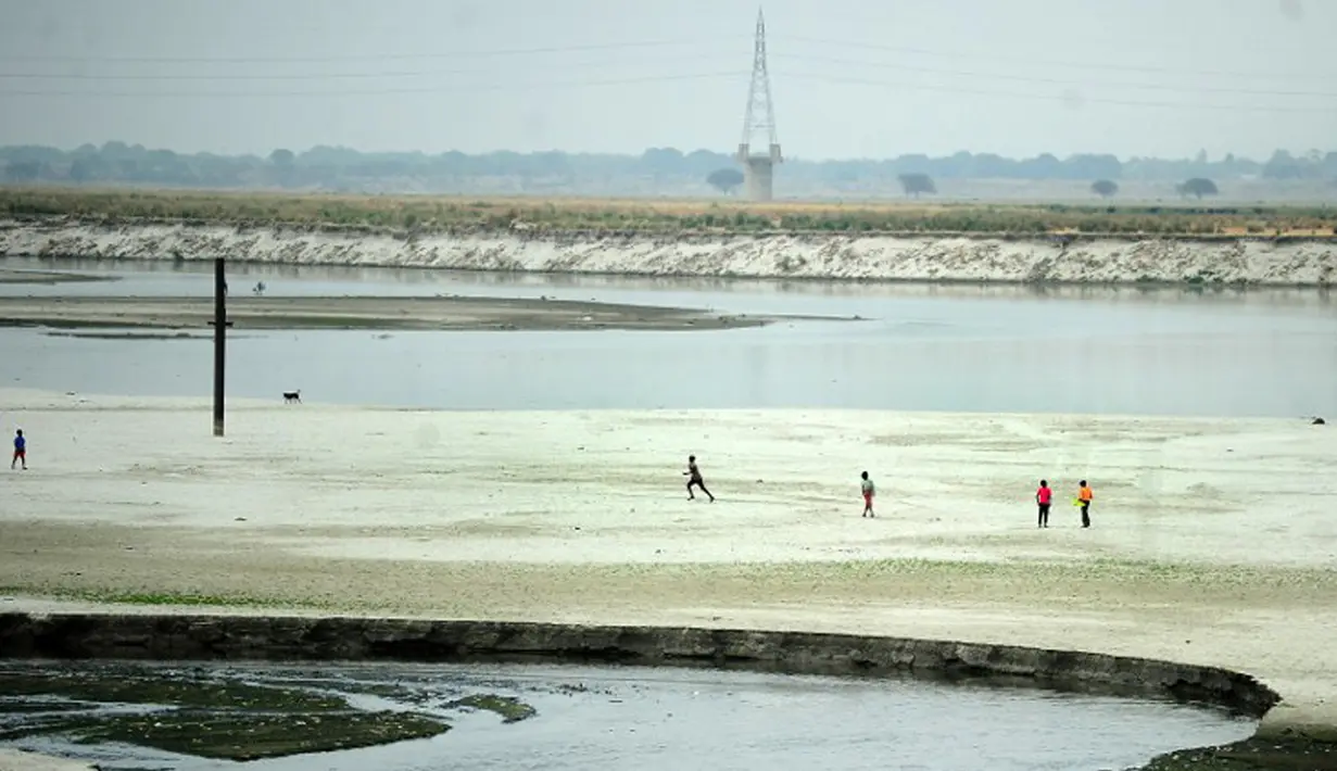 Sejumlah anak bermain di dekat sungai yang kering di Allahabad, India (3/6/2015). Cuaca panas yang melanda India tidak hanya menewaskan ratusan warga, tetapi mengubah sungai menjadi seperti lapangan.  (AFP PHOTO/SANJAY Kanojia) 
