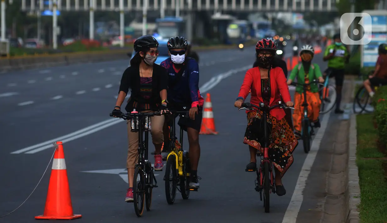 Sejumlah orang mengendarai sepeda dengan mengenakan kebaya di Kawasan Sudirman, Jakarta, Selasa (29/9/2020). Bersepeda dengan pakaian tradisional tersebut dilakukan untuk melestarikan budaya. (merdeka.com/Imam Buhori)