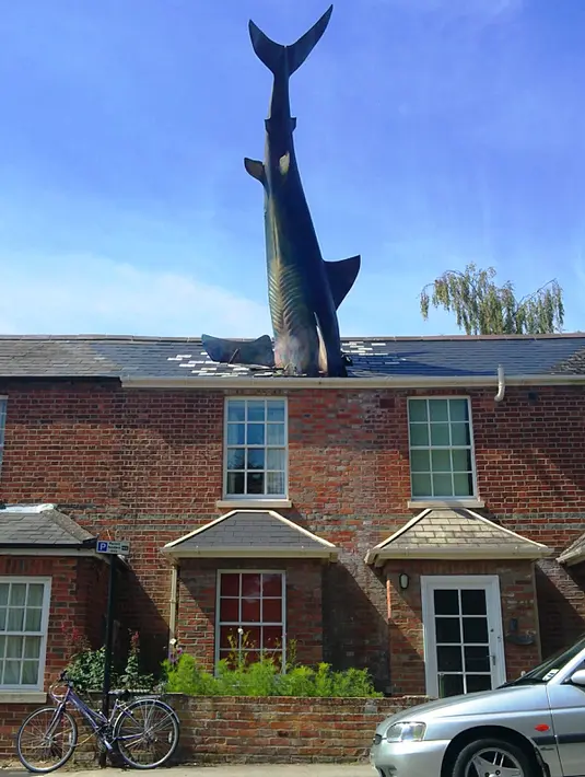 Patung unik ini bisa kita lihat di daratan Eropa, tepatnya di New High Street, Oxford, Inggris. Kalau biasanya patung berdiri di atas tanah, patung The Shark berbeda karena berada di atap rumah.  (demilked.com)
