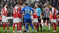 Wasit Stuart Attwell dan sejumlah pemain Arsenal dan Newcastle menunggu hasil VAR (Video Assistant Referee) pada laga lanjutan Liga Inggris 2023/2024 yang berlangsung di Stadion St. James' Park, Newcastle, Inggris, Minggu (05/11/2023) WIB. Gol kontroversial tersebut tetap disahkan oleh wasit meski telah meninjau VAR. (AFP/Oli Scarff)