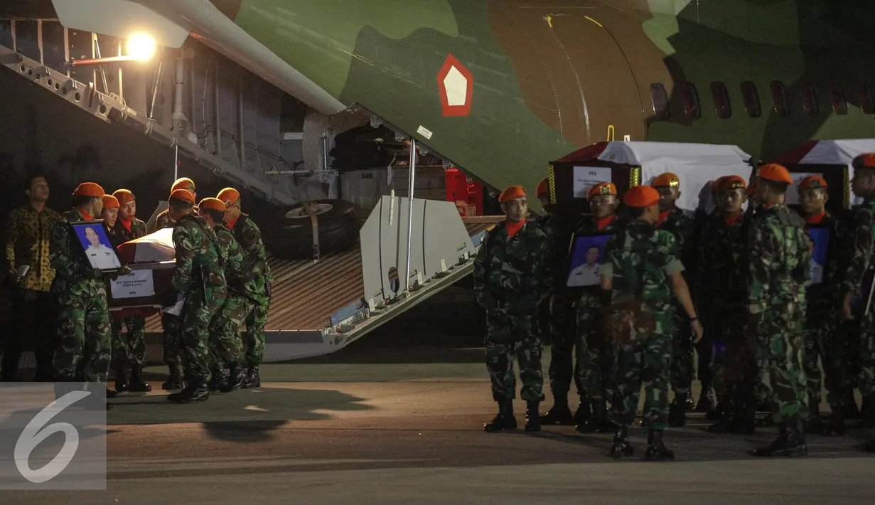 Prajurit menurunkan peti jenazah korban jatuhnya pesawat Hercules C-130, di Lanud Halim Perdanakusuma, Jakarta, Rabu (1/7/2015). Presiden Jokowi memimpin langsung upacara penerimaan jenazah. (Liputan6.com/Faizal Fanani)