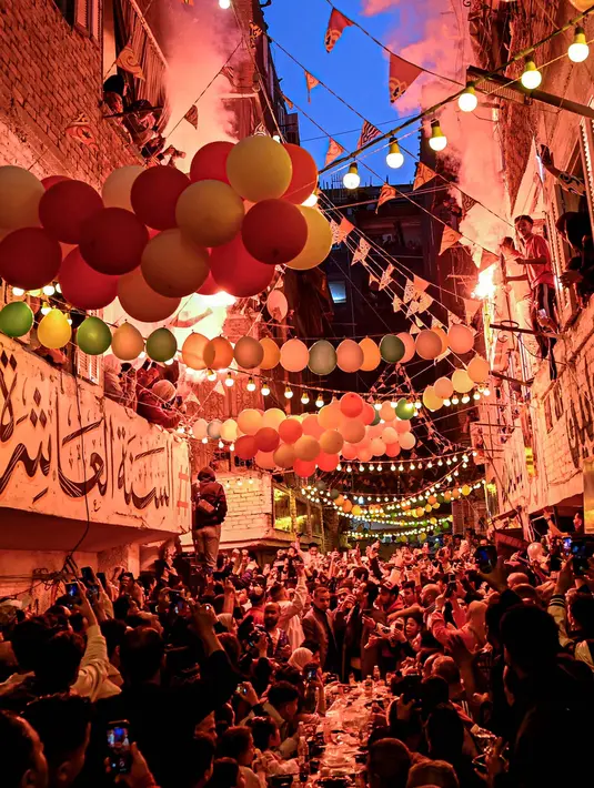 Sepanjang Ramadan, jalan-jalan utama di Ezbet Hamada dihiasi dengan meja-meja panjang yang dipenuhi dengan hidangan untuk berbuka puasa. (Khaled DESOUKI/AFP)