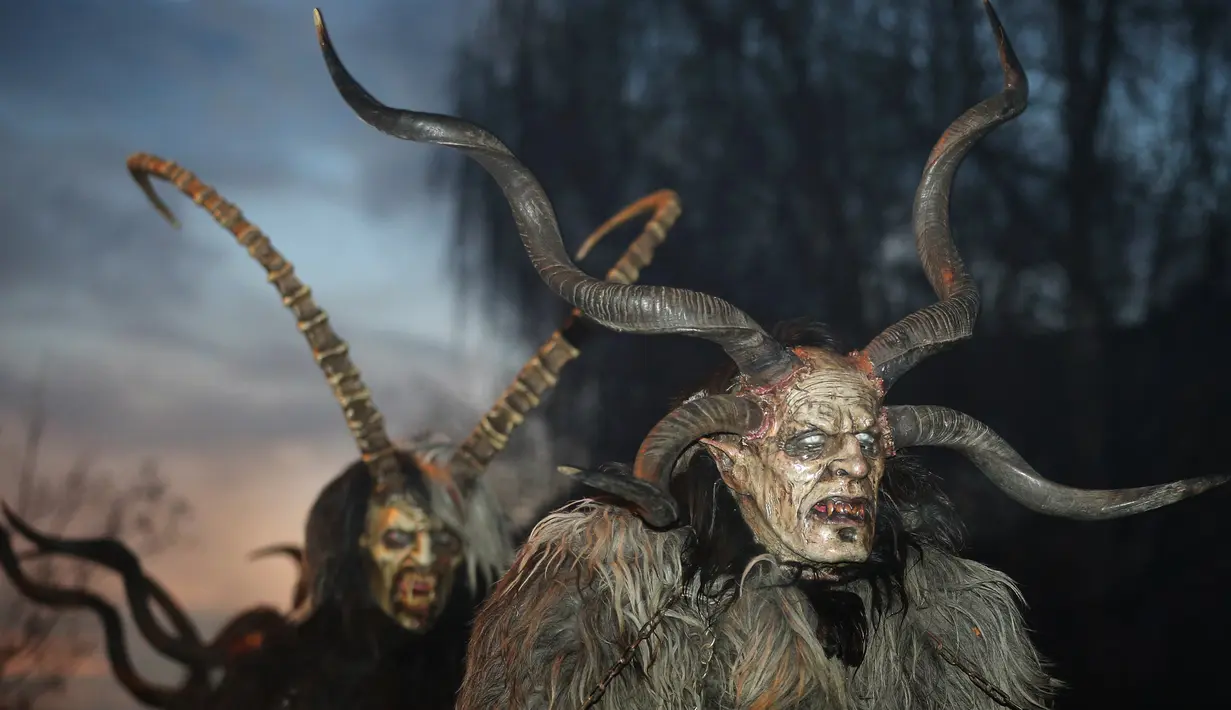 Seorang pria berpakaian seperti Krampus, mahkluk setengah kambing dan setengah iblis, dalam acara di Boerwang, Jerman, 24 November 2018. Dalam tradisi Natal ini Krampus berkeliaran di jalanan menakuti anak-anak yang nakal. (KARL-JOSEF HILDENBRAND/DPA/AFP)