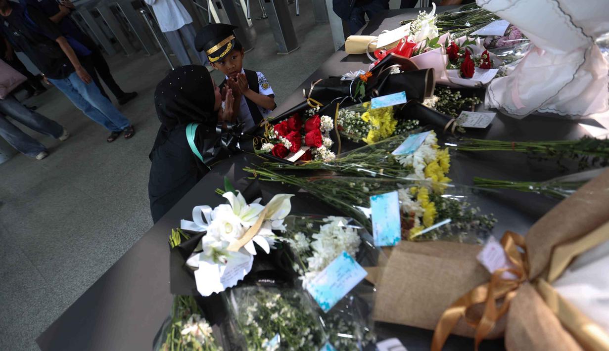 Pemandangan ini mewarnai aktivitas penumpang yang mulai berangsur normal pasca-kecelakaan kereta pada Senin (27/4/2026). Tampak dalam foto, seorang anak membaca doa usai meletakkan karangan bunga di dekat pintu masuk peron Stasiun Bekasi Timur, Bekasi, Jawa Barat, Kamis (30/4/2026). (Kapanlagi.com/Budy Santoso)