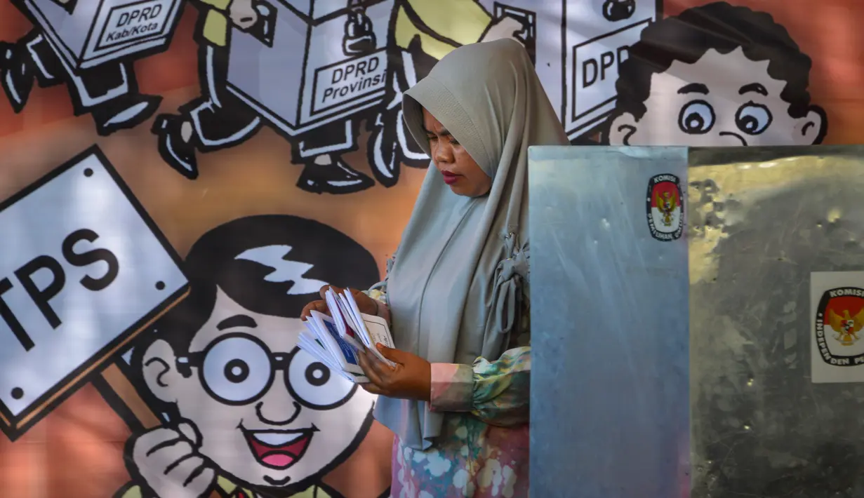 Seorang wanita memeriksa surat suara selama latihan pra-pemilihan di Banda Aceh, provinsi Aceh (6/4). Indonesia akan menyelenggarakan Pemilu serentak pada 17 April 2019. (AFP Photo/Chaideer Mahyudin)