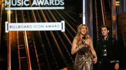 Celine Dion memeluk Rene-Charles Angelil saat menerima penghargaan Icon Award di ajang Billboard Music Awards 2016 di Las Vegas, Minggu (22/5). Kemunculan Rene-Charles yang bermata biru dengan rambut gelap sukses mencuri perhatian. (REUTERS/Mario Anzuoni)
