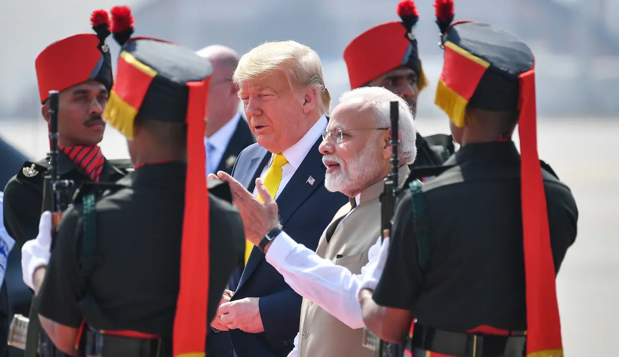 PM India, Narendra Modi menyambut kedatangan Presiden AS Donald Trump di Bandara Internasional Sardar Vallabhbhai Patel di Ahmedabad, Senin (24/2/2020). Trump dan Modi dijadwalkan menghadiri acara yang diikuti sekitar 100 ribu orang di stadion kriket terbesar dunia di Gujarat. (MANDEL NGAN/AFP)
